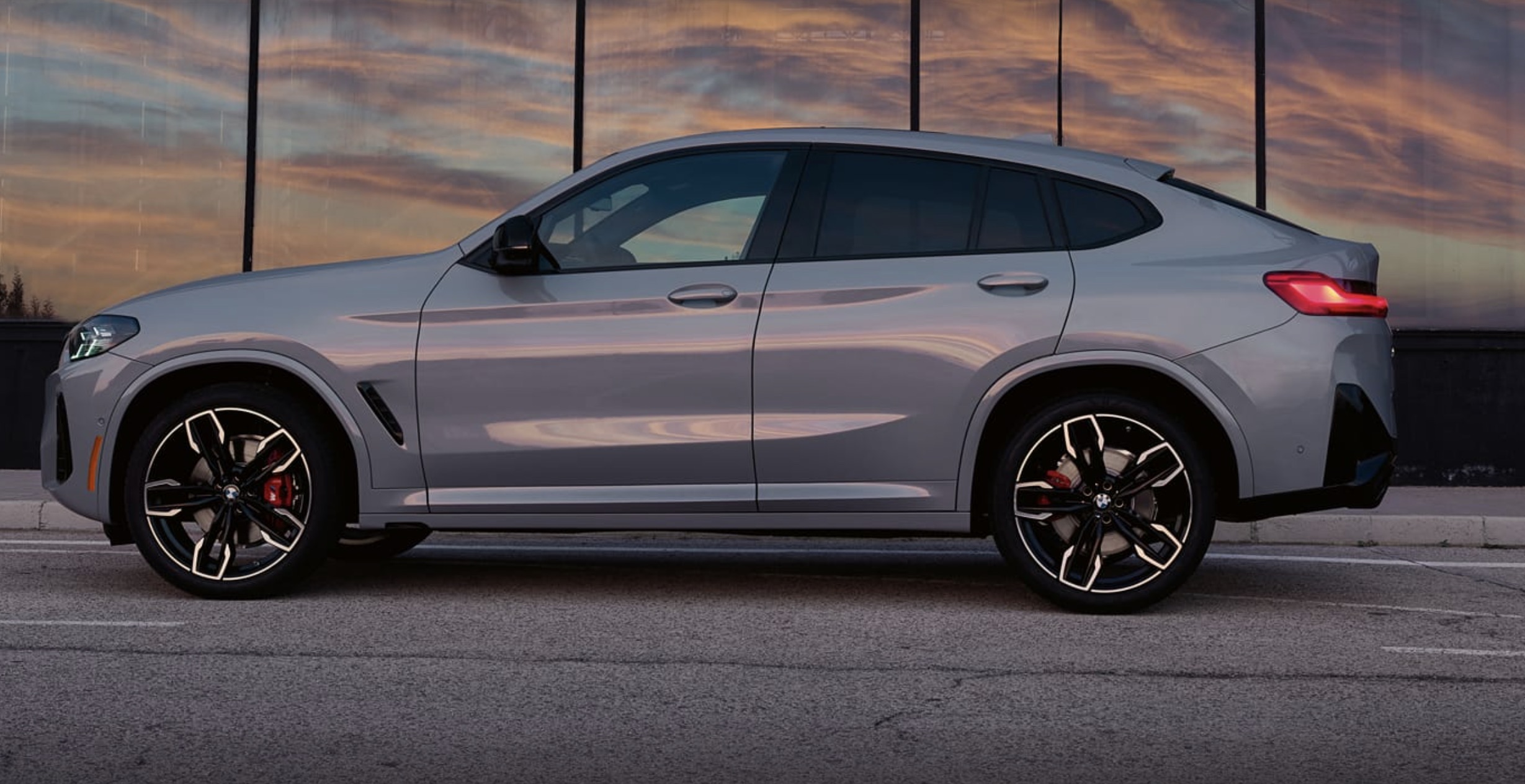 BMW X4 M30i parked with the sun setting out of frame.