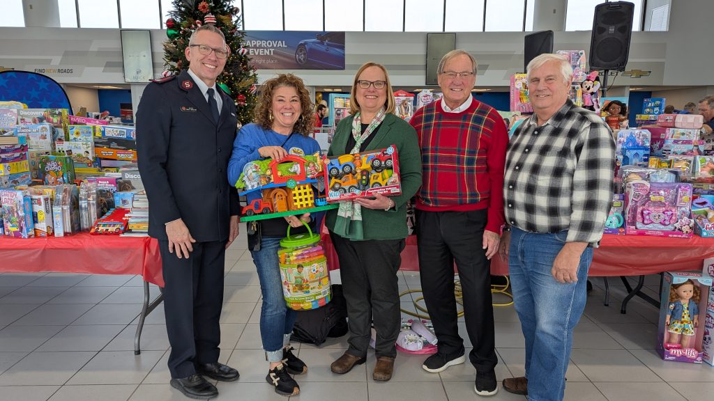 A group of Bachrodt On State employees standing in forn tof toy drive donations
