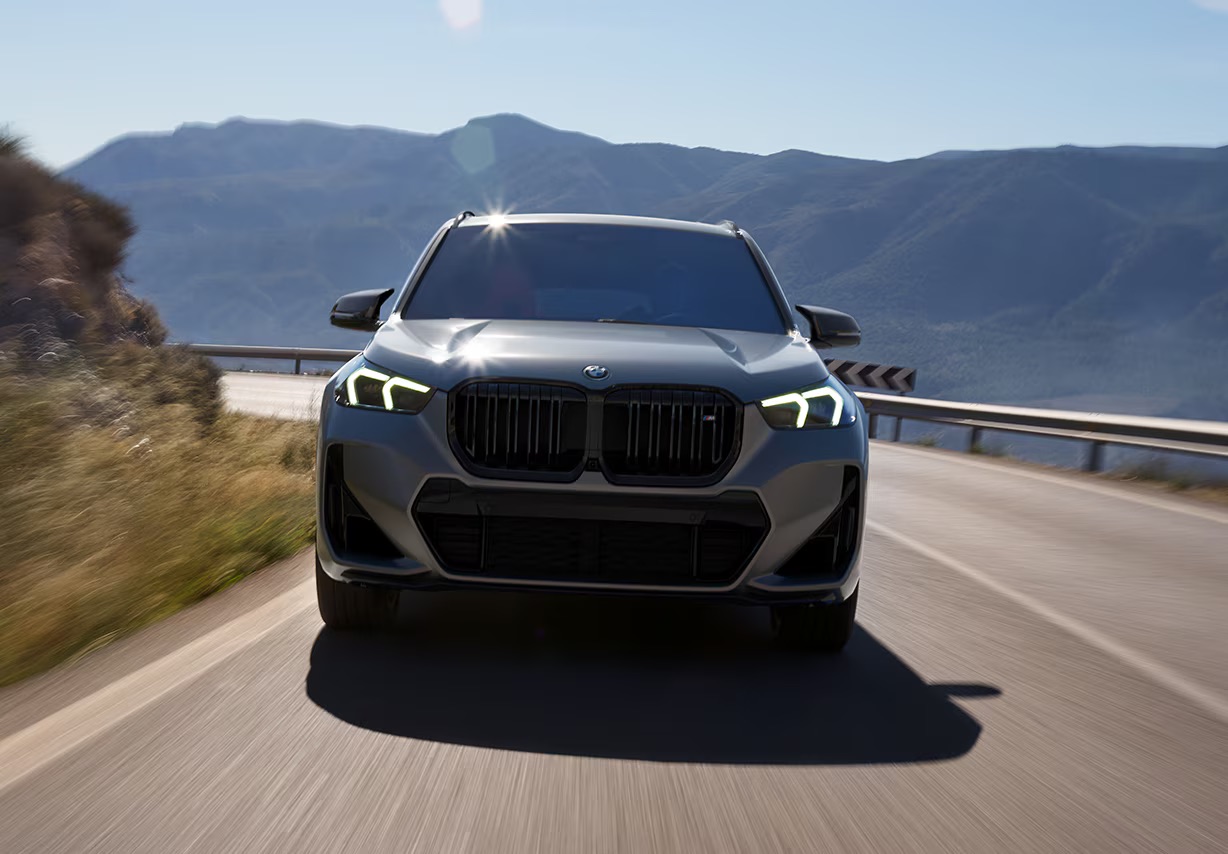 Gray 2025 BMW X1 M35i driving through mountains in Rockford, IL