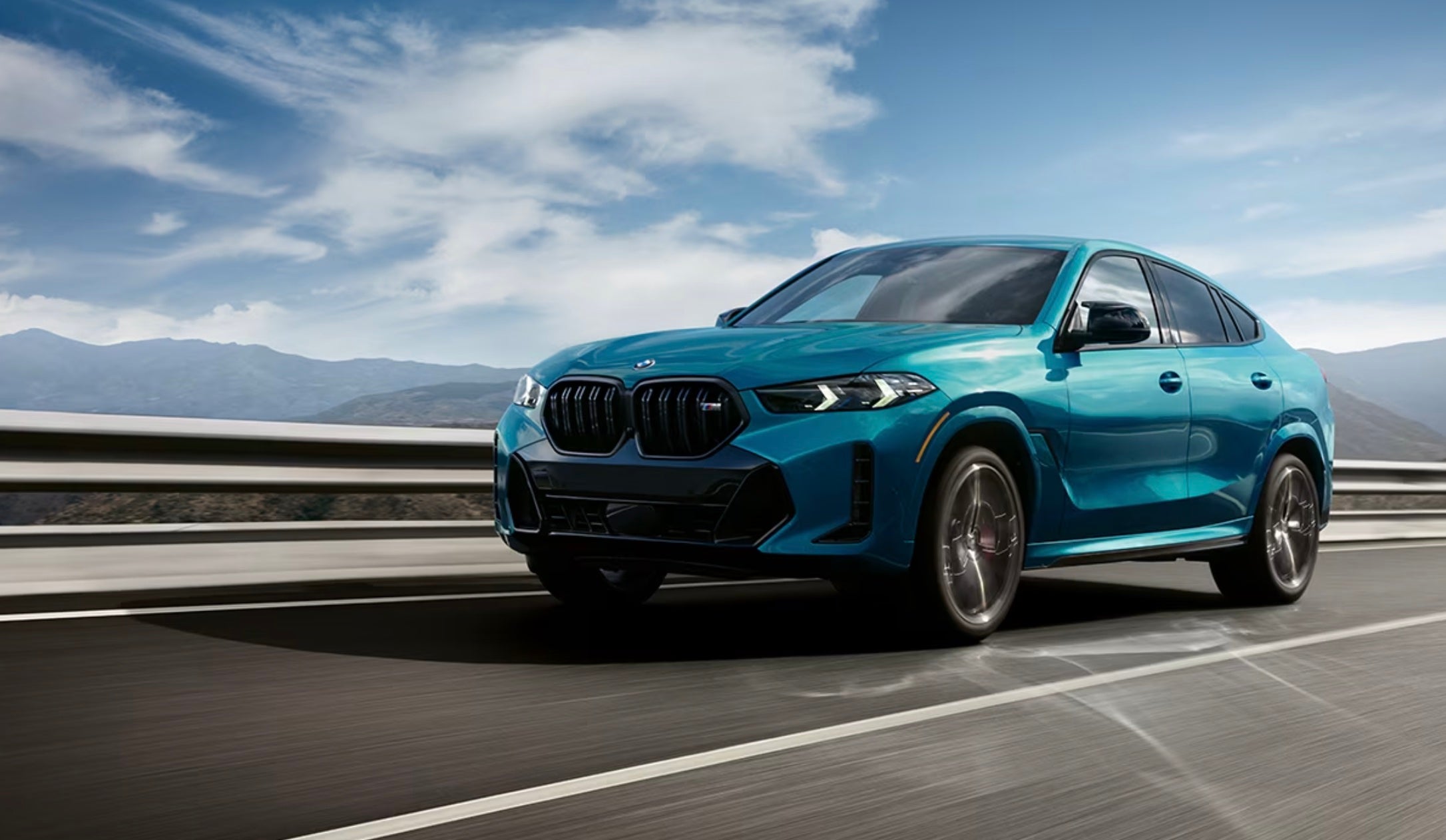 The BMW X6 from Lou Bachrodt BMW in blue driving on the open roads of Illinois.
