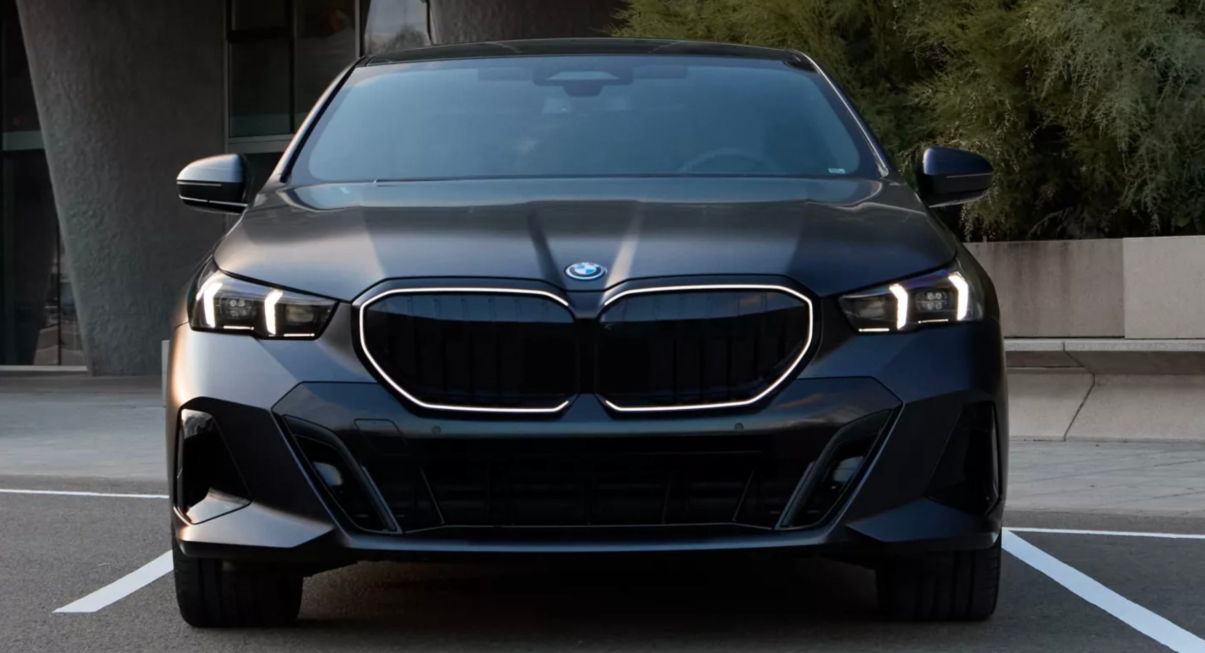 BMW 550e xDrive parked in a driveway in Elgin, IL in the BMW signature kidney iconic glow.