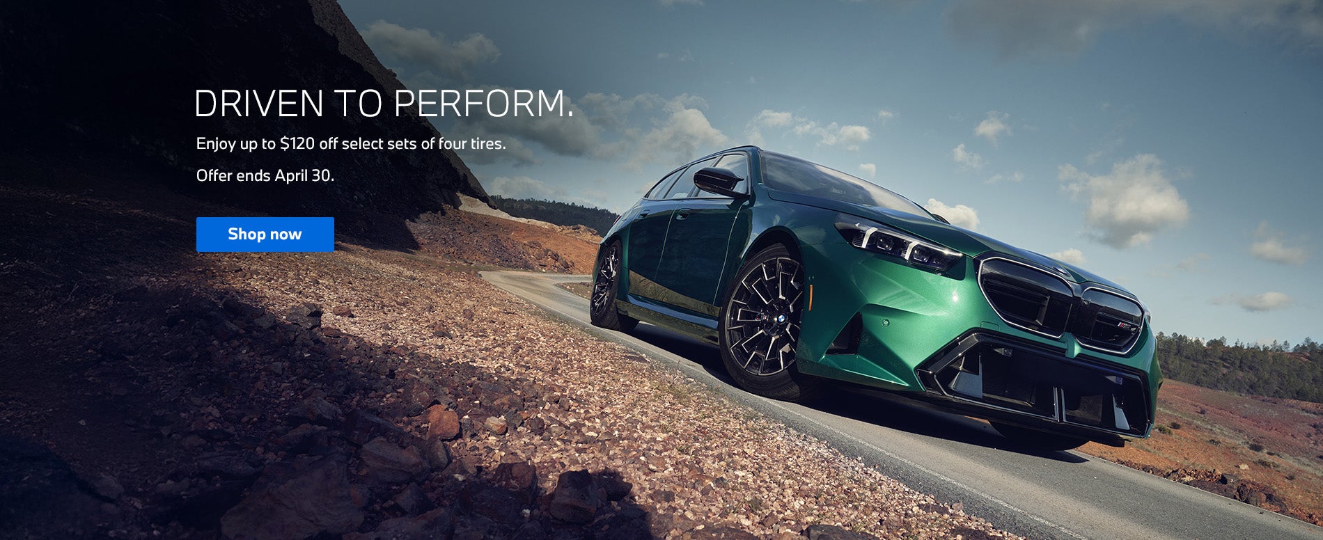 Front three-quarter view of a BMW M5 driving along a curved 