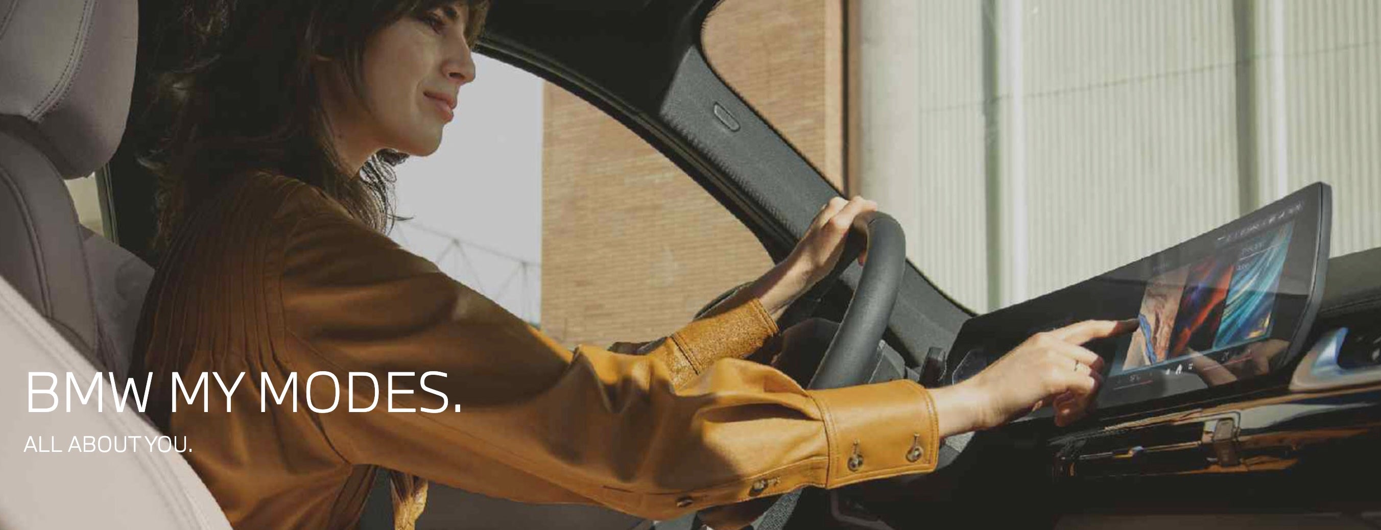 A woman selecting drive modes on her BMW dashboard.