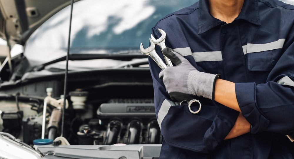 BMW transmission inspection and a man holding tools