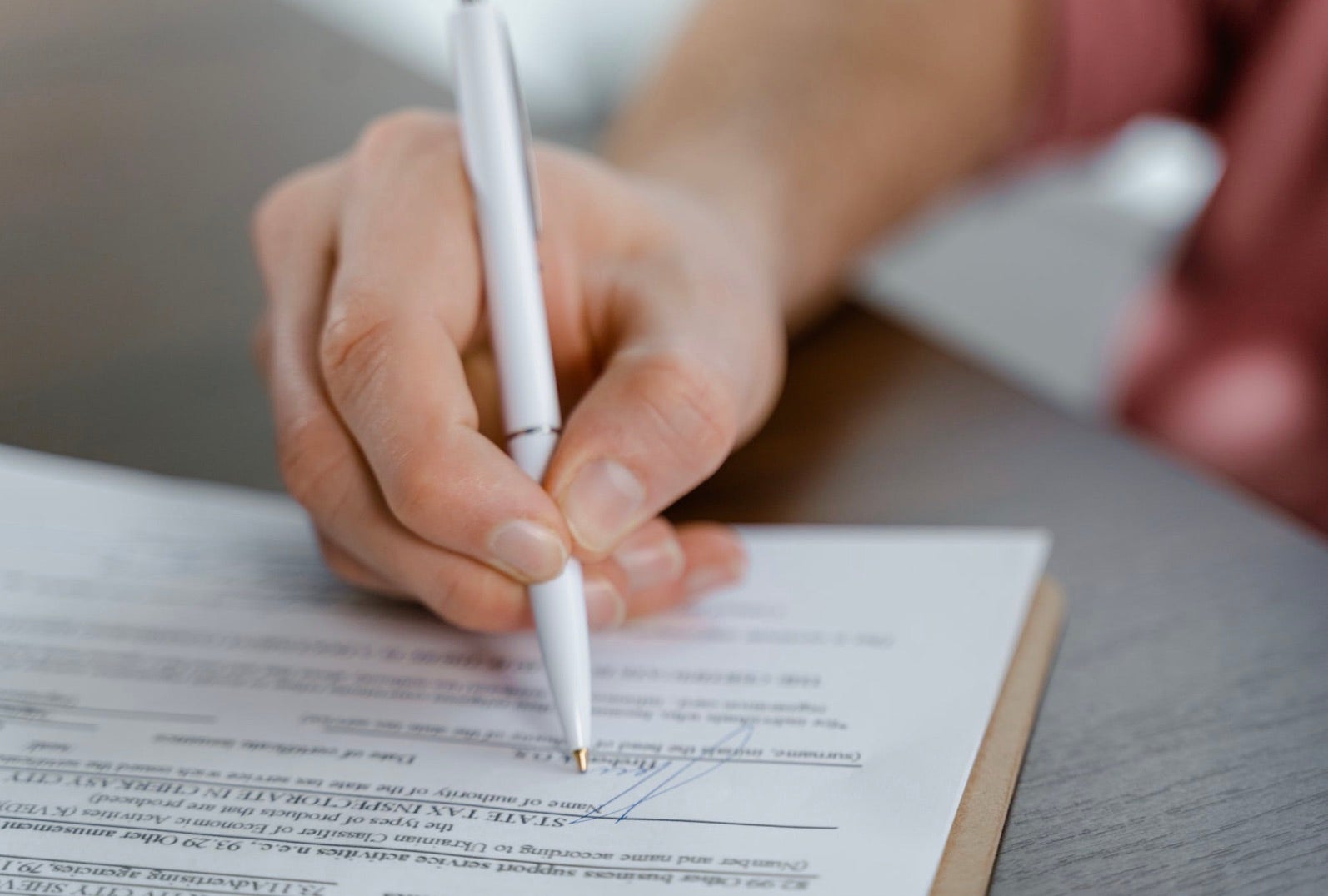 Woman signing her used BMW M6 financing application.